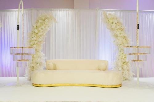 Scène de mariage romantique avec canapé des mariés et arches florales