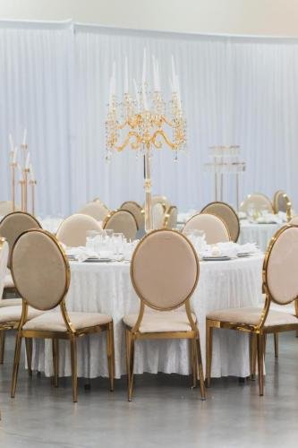 Table ronde mariage luxe avec chaises dorées et chandelier cristal