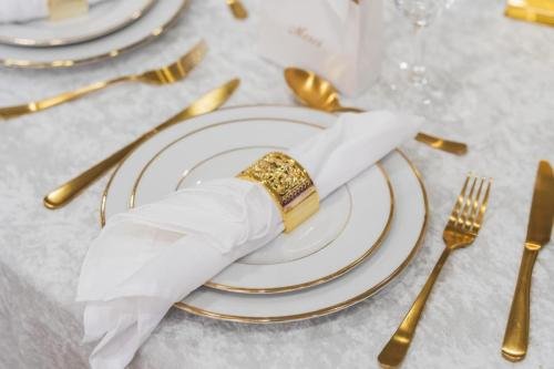 Dressage de table mariage luxe avec couverts dorés et rond de serviette