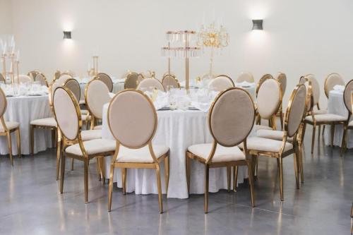 Tables rondes de mariage avec chaises dorées et nappes blanches