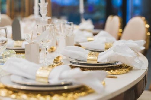 Détail dressage table mariage luxe avec ronds de serviette dorés